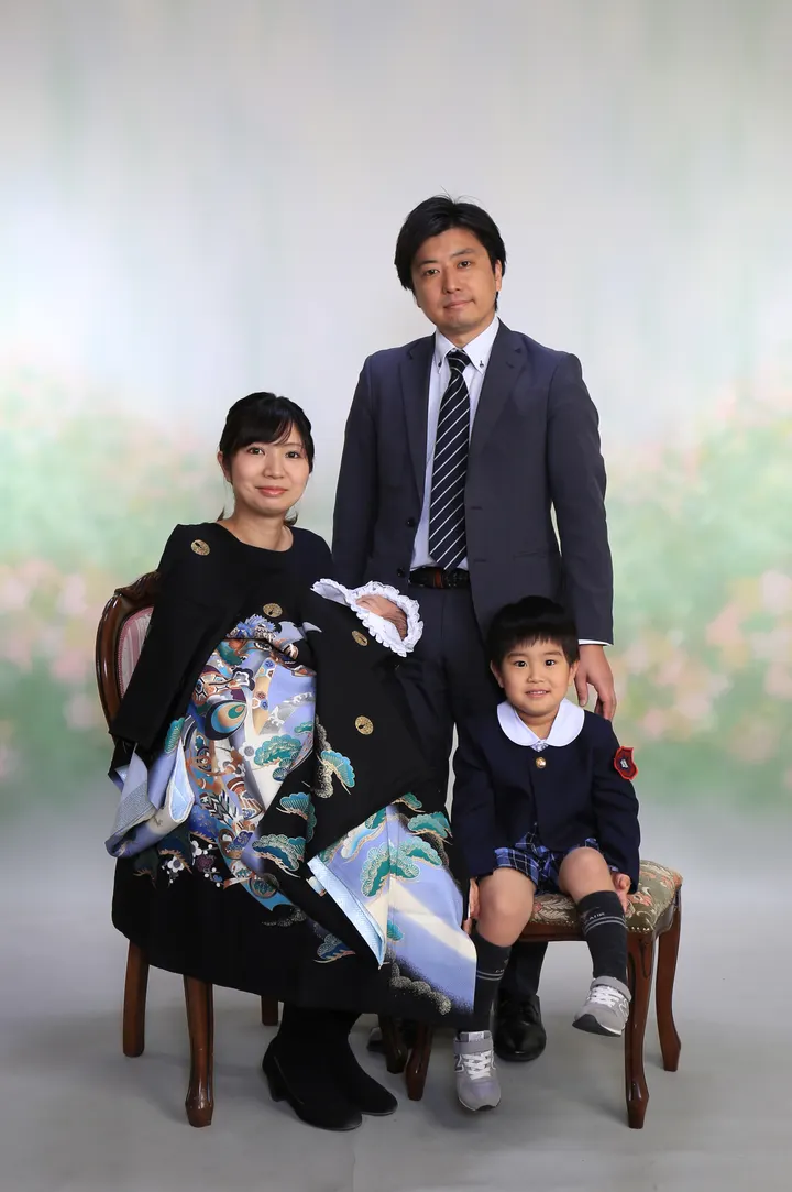 お宮参りの記念撮影 赤ちゃんを抱くお母さんを囲む家族4人の集合写真