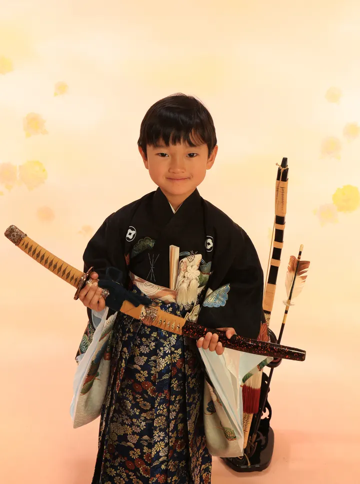 七五三の記念撮影 黒紋付袴で刀を手にした男の子の立ち姿